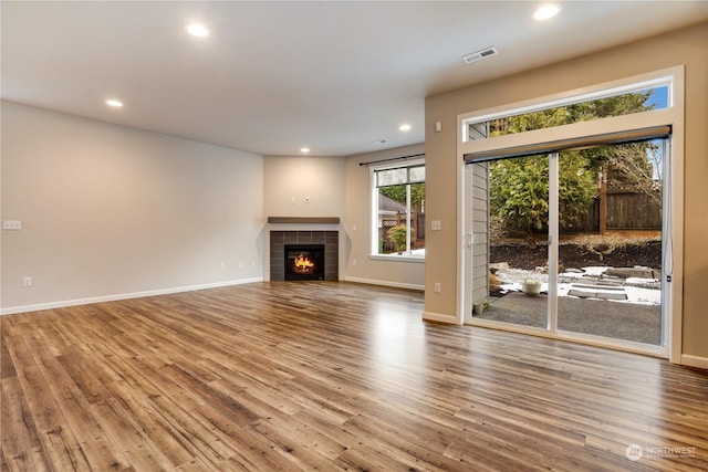 unfurnished living room with a fireplace and light hardwood / wood-style floors