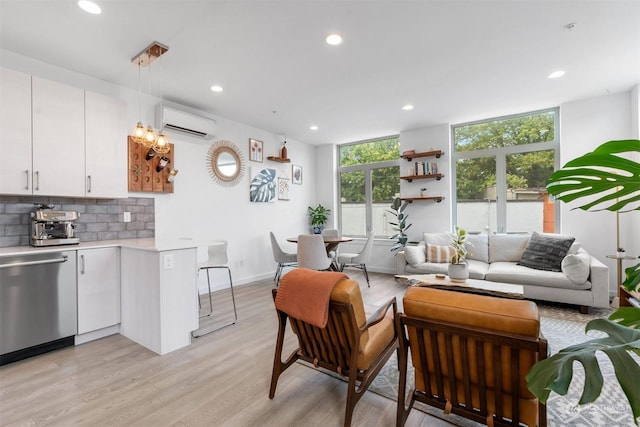 living room with light hardwood / wood-style floors and an AC wall unit