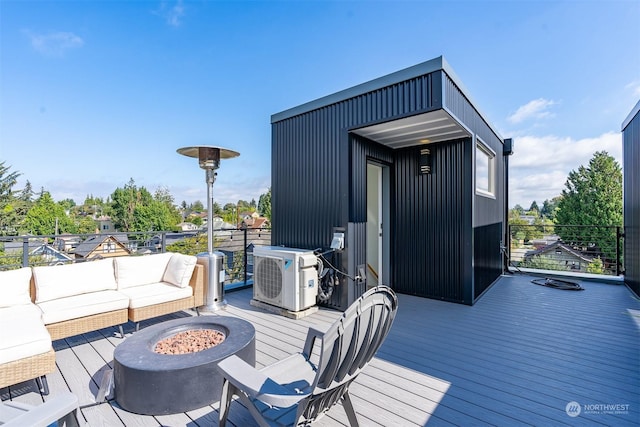 deck featuring ac unit and an outdoor living space with a fire pit