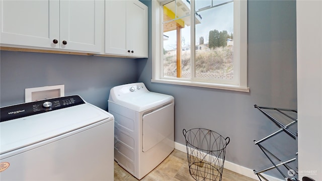 laundry room featuring washer and dryer and cabinets