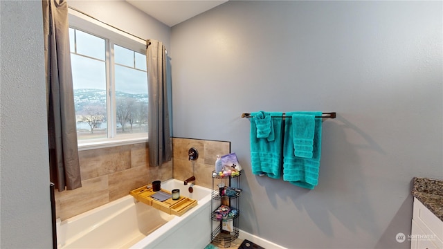 bathroom featuring a mountain view, a bath, and vanity