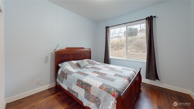 bedroom with dark hardwood / wood-style floors