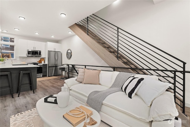 living room with sink and light hardwood / wood-style flooring