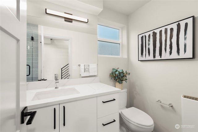 bathroom featuring walk in shower, vanity, toilet, and radiator heating unit