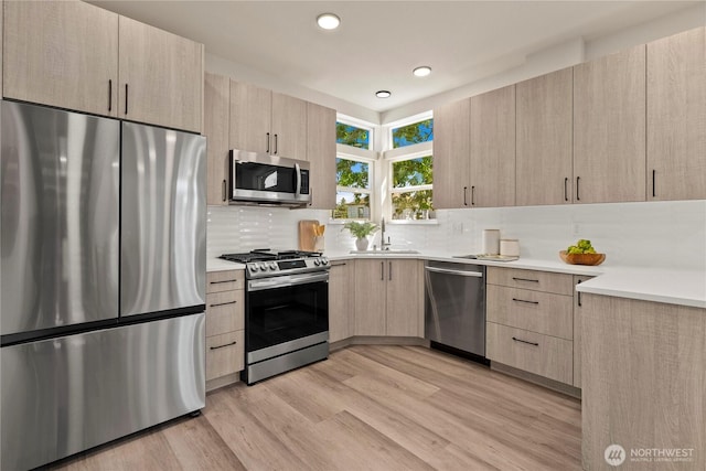 922B N 35th St, Seattle, WA 98103 - kitchen featuring stainless steel appliances, light brown cabinetry, modern cabinets, light countertops, and recessed lighting