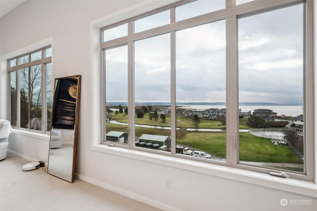 interior space with carpet and a water view