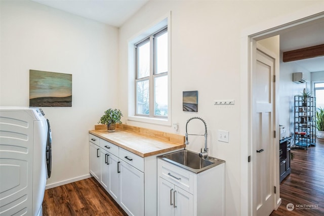 interior space featuring white cabinets, washer / clothes dryer, dark hardwood / wood-style flooring, sink, and butcher block countertops