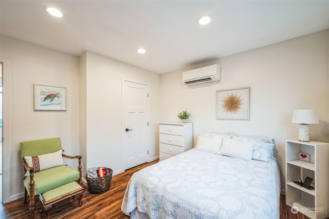 bedroom featuring an AC wall unit and dark hardwood / wood-style floors