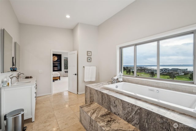 bathroom with vanity, tile patterned flooring, and tiled tub