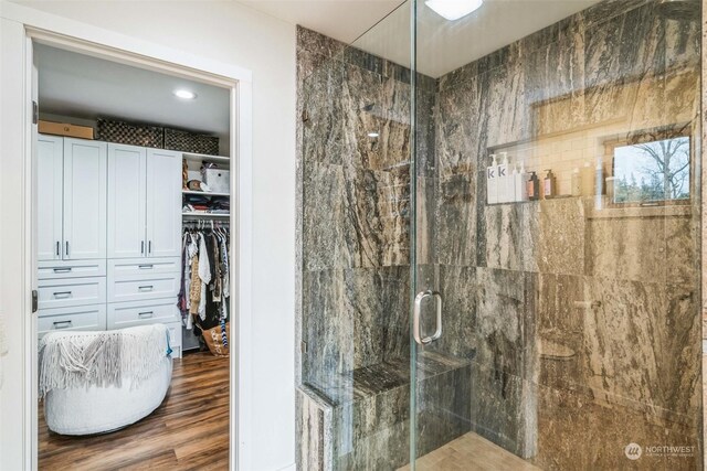 bathroom featuring a shower with shower door and wood-type flooring