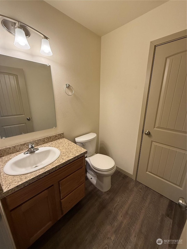 bathroom featuring vanity, toilet, and wood-type flooring