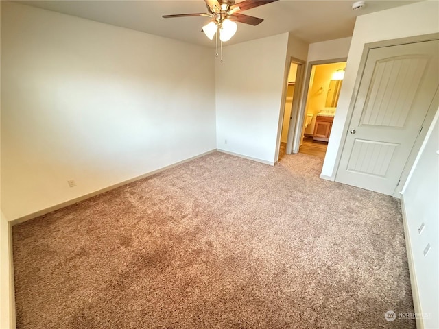 unfurnished bedroom with carpet flooring, a closet, ensuite bathroom, and ceiling fan