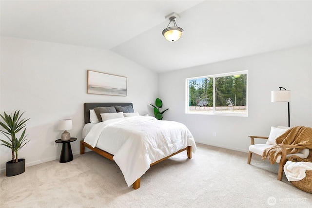 bedroom featuring baseboards, lofted ceiling, and light carpet