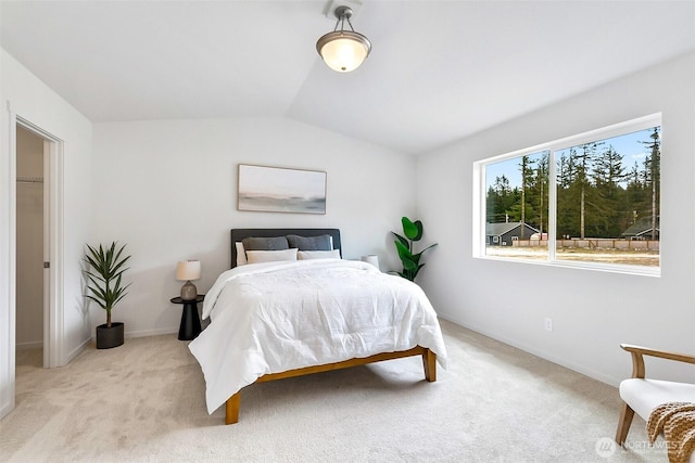 bedroom featuring baseboards, vaulted ceiling, and light carpet