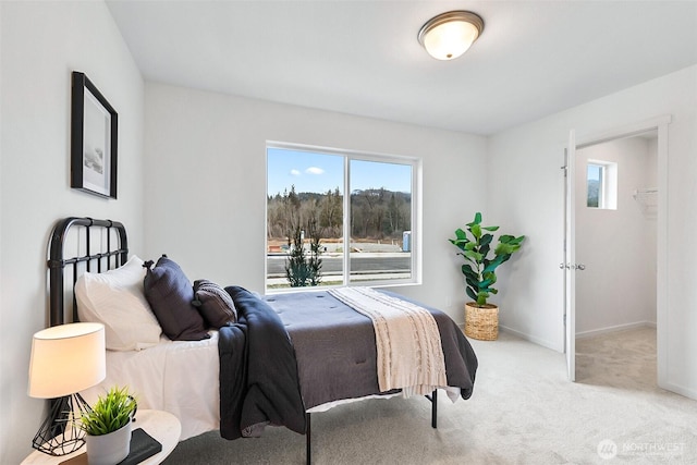 bedroom with baseboards and light carpet