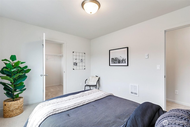 bedroom featuring baseboards, visible vents, and light carpet