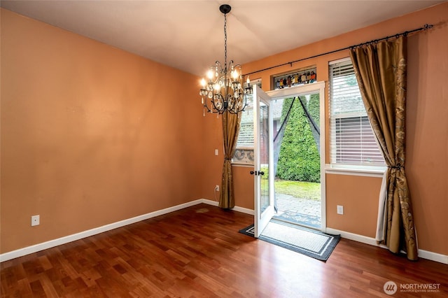 doorway to outside with hardwood / wood-style flooring and a chandelier