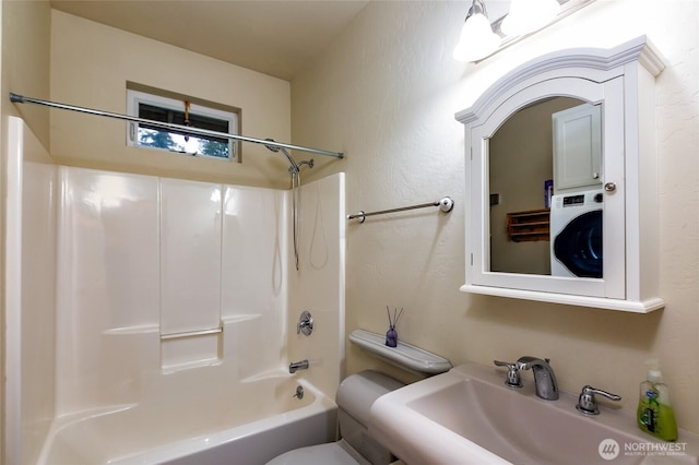 full bathroom featuring sink, shower / tub combination, toilet, and washer / clothes dryer