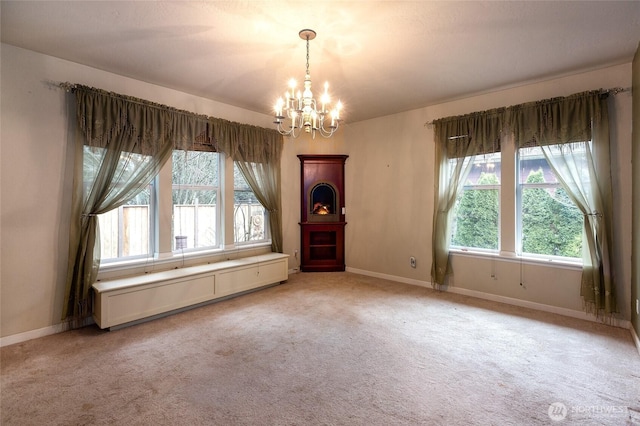 empty room featuring light colored carpet and a notable chandelier