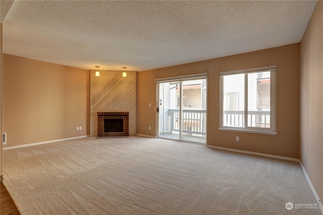 unfurnished living room featuring wood walls, light carpet, a textured ceiling, and a brick fireplace