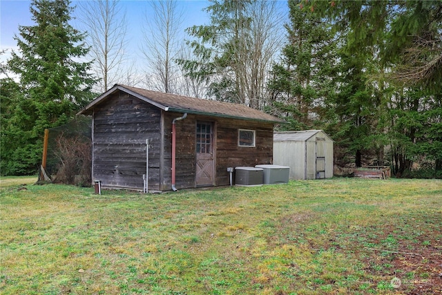 view of outdoor structure featuring a yard and central AC unit