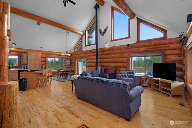 living room featuring beam ceiling, high vaulted ceiling, rustic walls, and sink