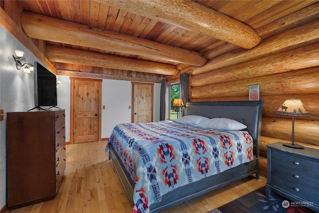 bedroom with beam ceiling, light hardwood / wood-style floors, rustic walls, and wood ceiling