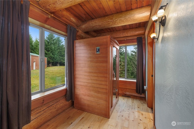 entryway featuring wooden walls, light hardwood / wood-style flooring, beamed ceiling, and wood ceiling