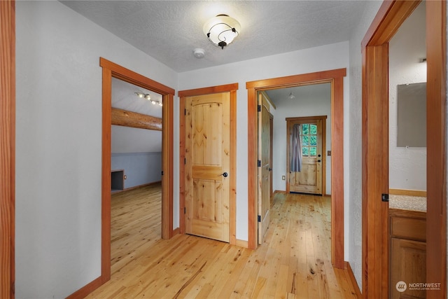 corridor featuring light hardwood / wood-style floors and a textured ceiling