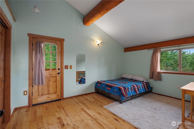 bedroom featuring lofted ceiling with beams and light hardwood / wood-style floors