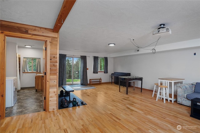 miscellaneous room featuring hardwood / wood-style flooring, beam ceiling, and a textured ceiling