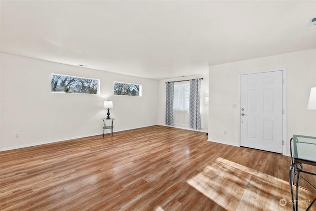 empty room with plenty of natural light and wood-type flooring