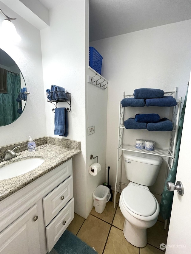 bathroom featuring tile patterned floors, vanity, and toilet