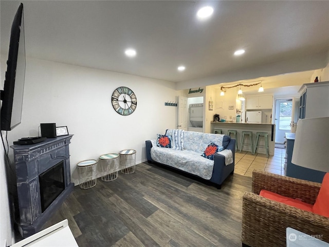 living room featuring dark hardwood / wood-style floors and stacked washer and clothes dryer