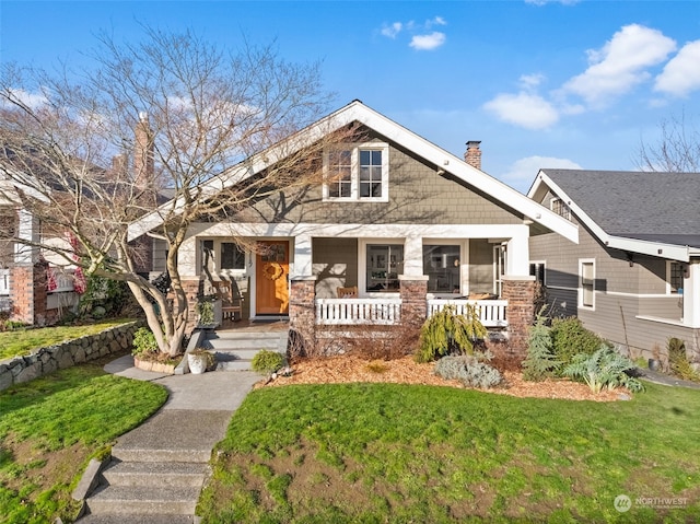 craftsman house featuring covered porch and a front lawn