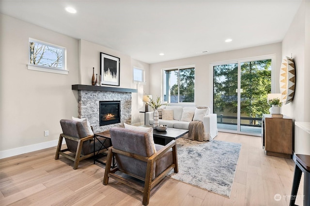 living room with a fireplace and light wood-type flooring