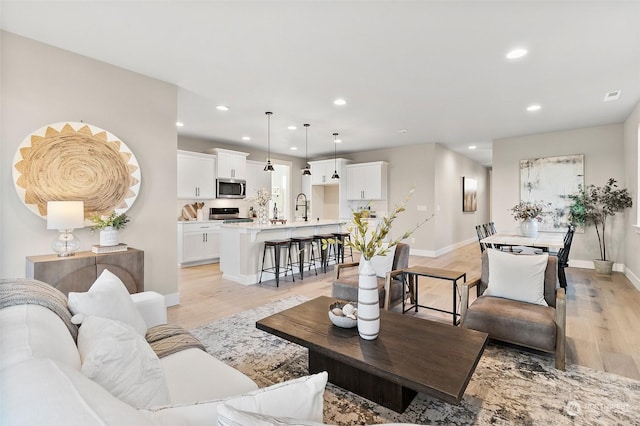 living room with sink and light hardwood / wood-style floors