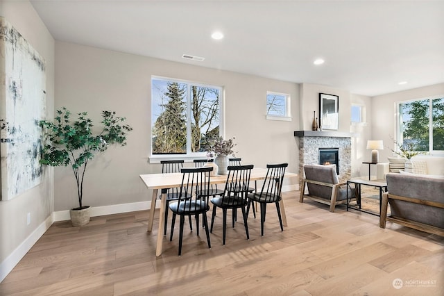 dining room featuring a fireplace and light wood-type flooring