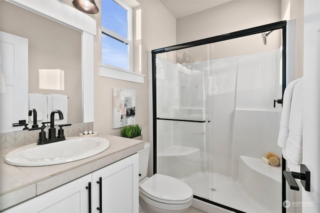 bathroom featuring vanity, toilet, and an enclosed shower