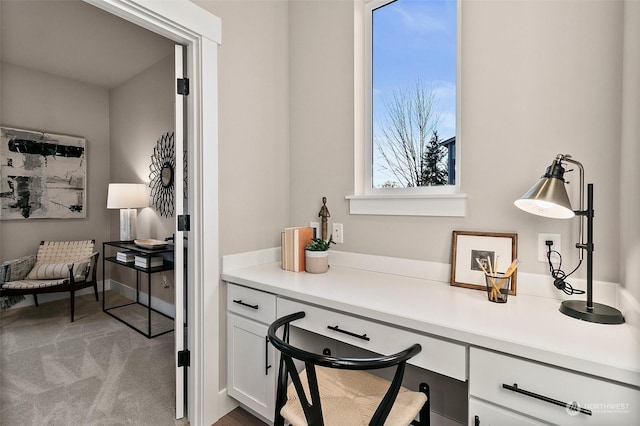 carpeted home office with built in desk