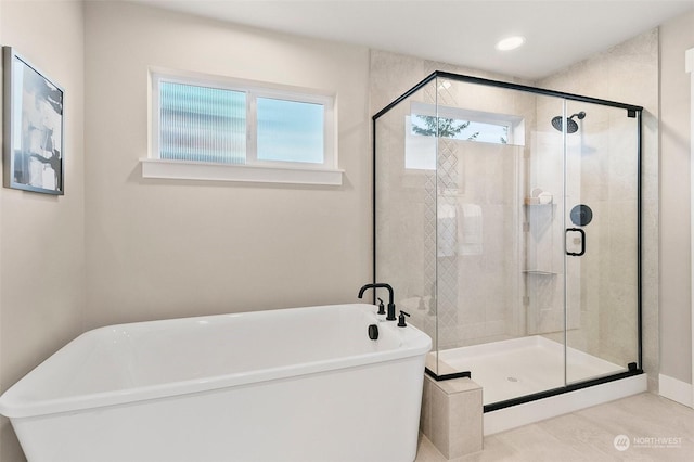 bathroom with shower with separate bathtub and a wealth of natural light