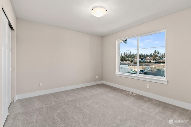 unfurnished room featuring light carpet