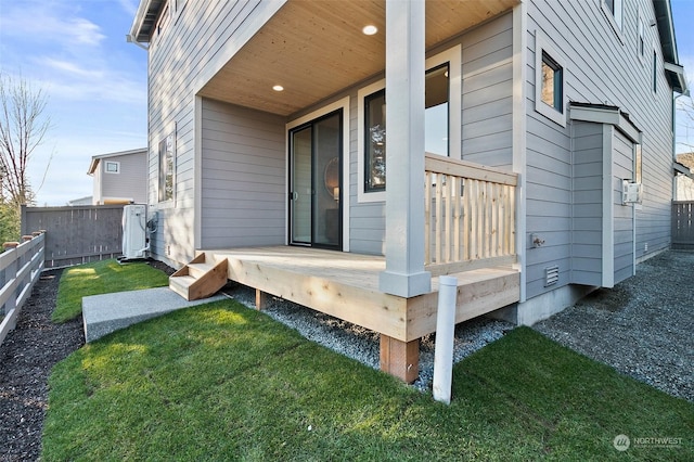 entrance to property with cooling unit and a lawn