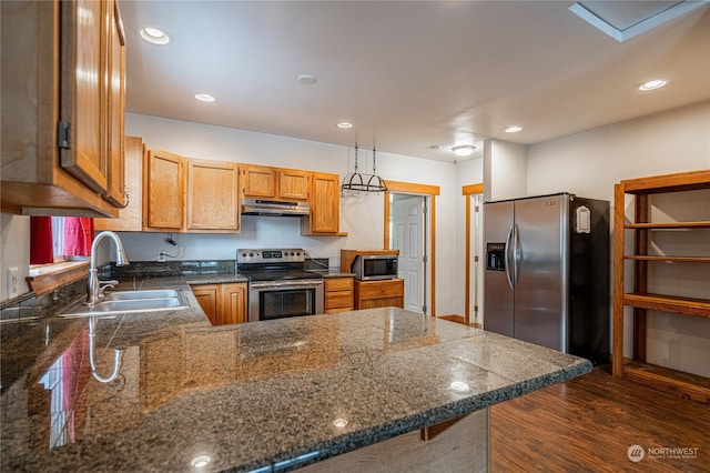 kitchen featuring appliances with stainless steel finishes, pendant lighting, sink, and kitchen peninsula