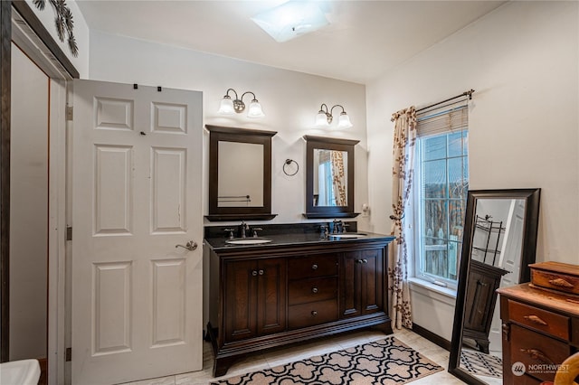 bathroom featuring vanity, tile patterned floors, and a skylight