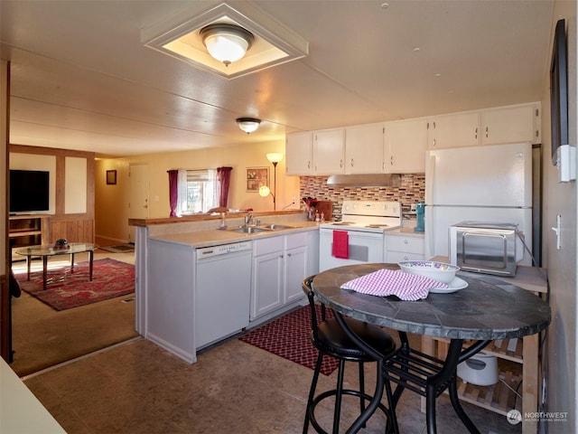 kitchen with kitchen peninsula, white appliances, white cabinets, and sink