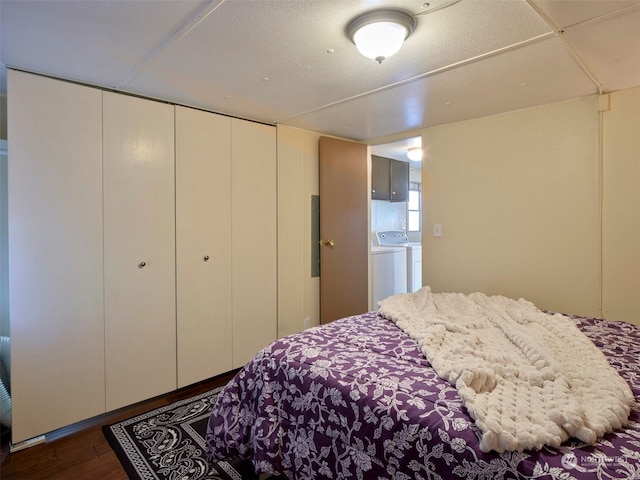 bedroom with washer and dryer, a closet, and dark wood-type flooring