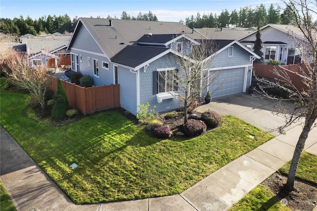 ranch-style house featuring fence, concrete driveway, a front lawn, a garage, and a residential view