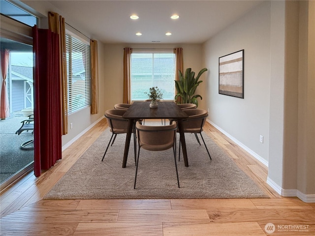 dining space with a wealth of natural light, recessed lighting, light wood-style flooring, and baseboards