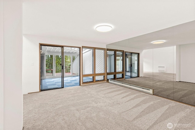 carpeted empty room featuring baseboard heating